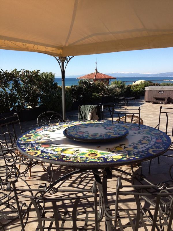 Terrazzo a Genova con alloro, bougainvillea e photinia in vaso, vista mare — realizzazione Peirano Vivai